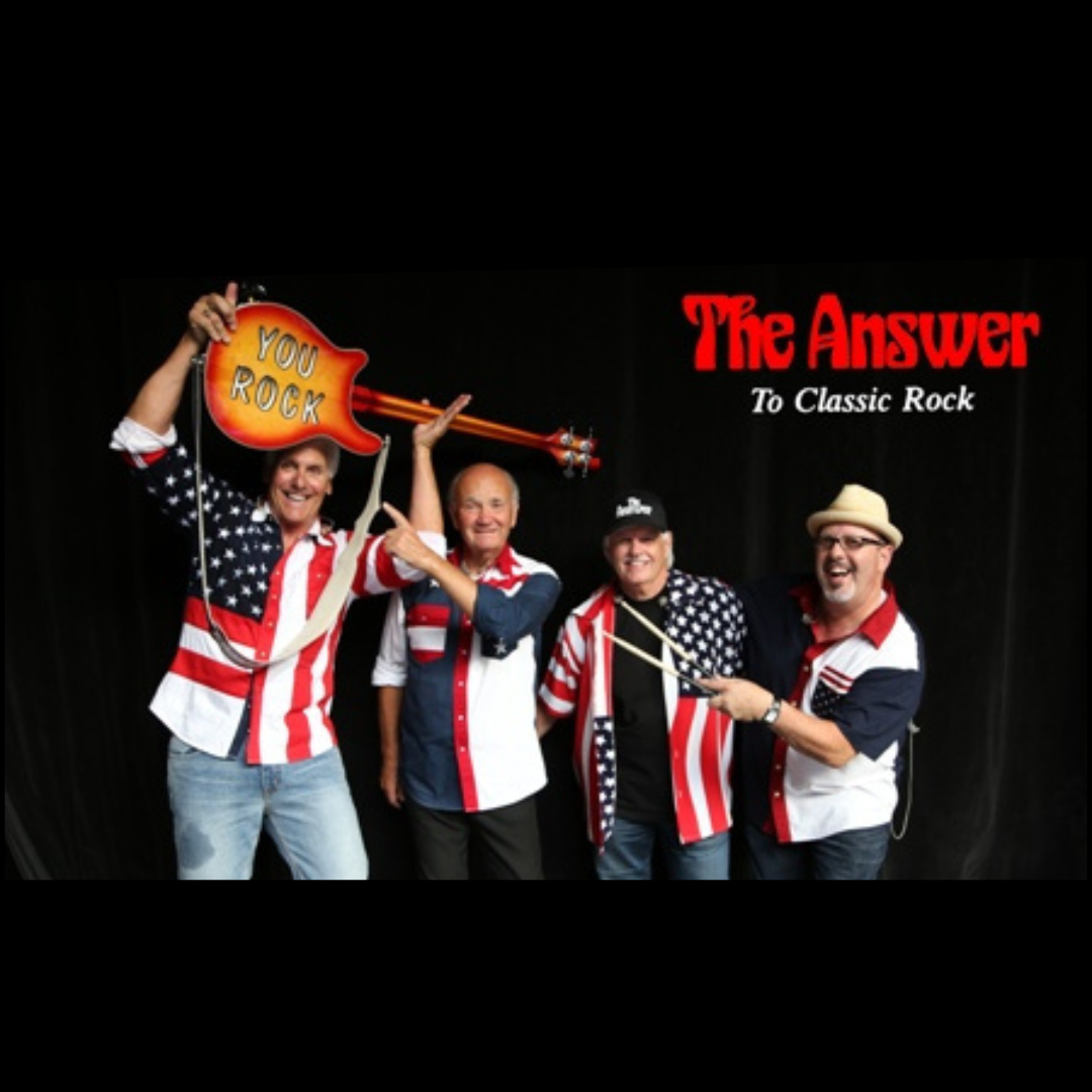 A group of four individuals stands in front of a black backdrop wearing shirts patterned with the American flag. One person holds a guitar overhead with the words “YOU ROCK” printed on it. To the right, stylized red text reads “The Answer” with smaller text underneath saying “To Classic Rock.”
