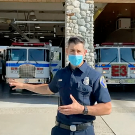 Firefighter in front of a fire station