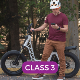 man with ebike with helmet on and phone in hand